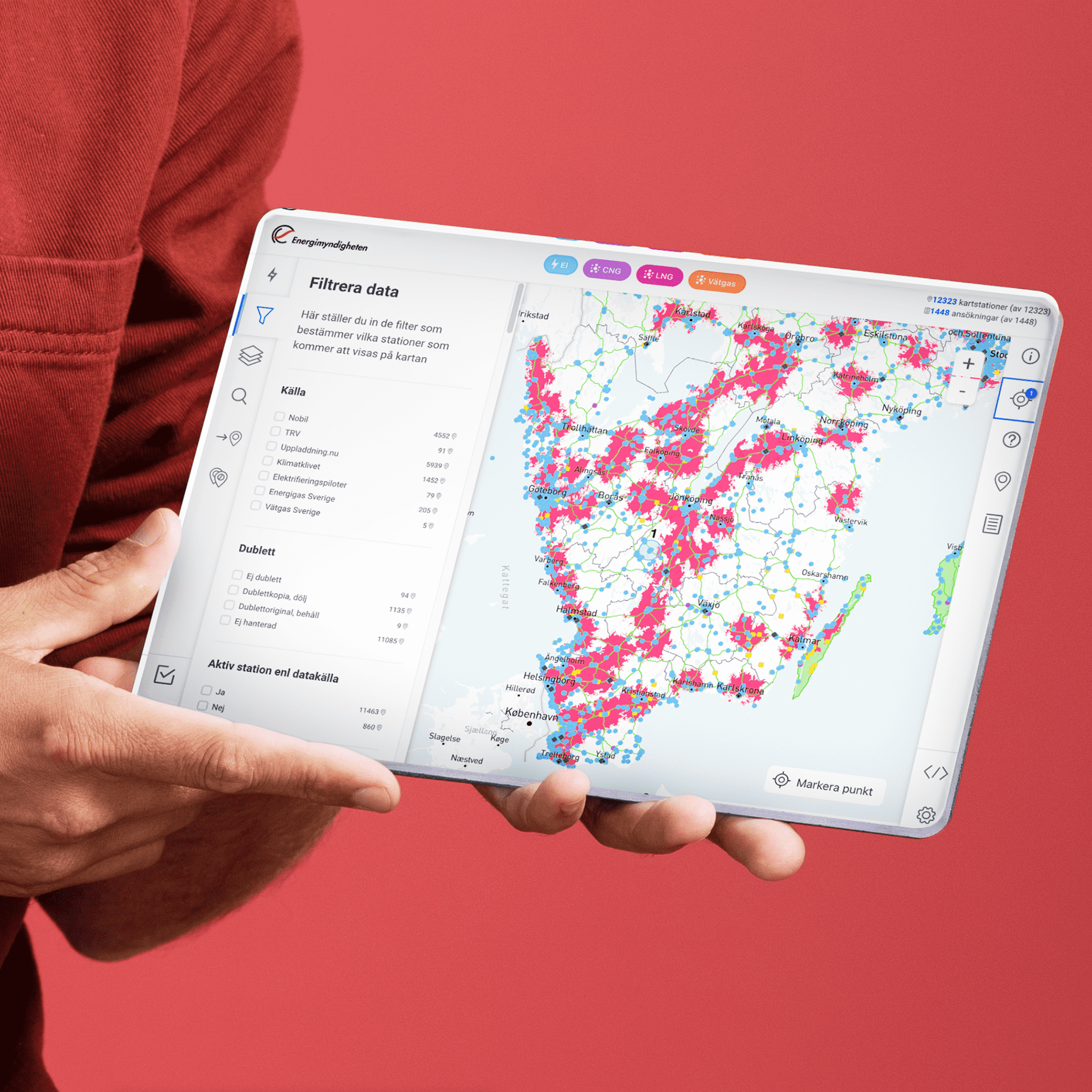 Person som håller i en iPad-liknande prototyp som visar webbapplikationen Laddstationskartan.