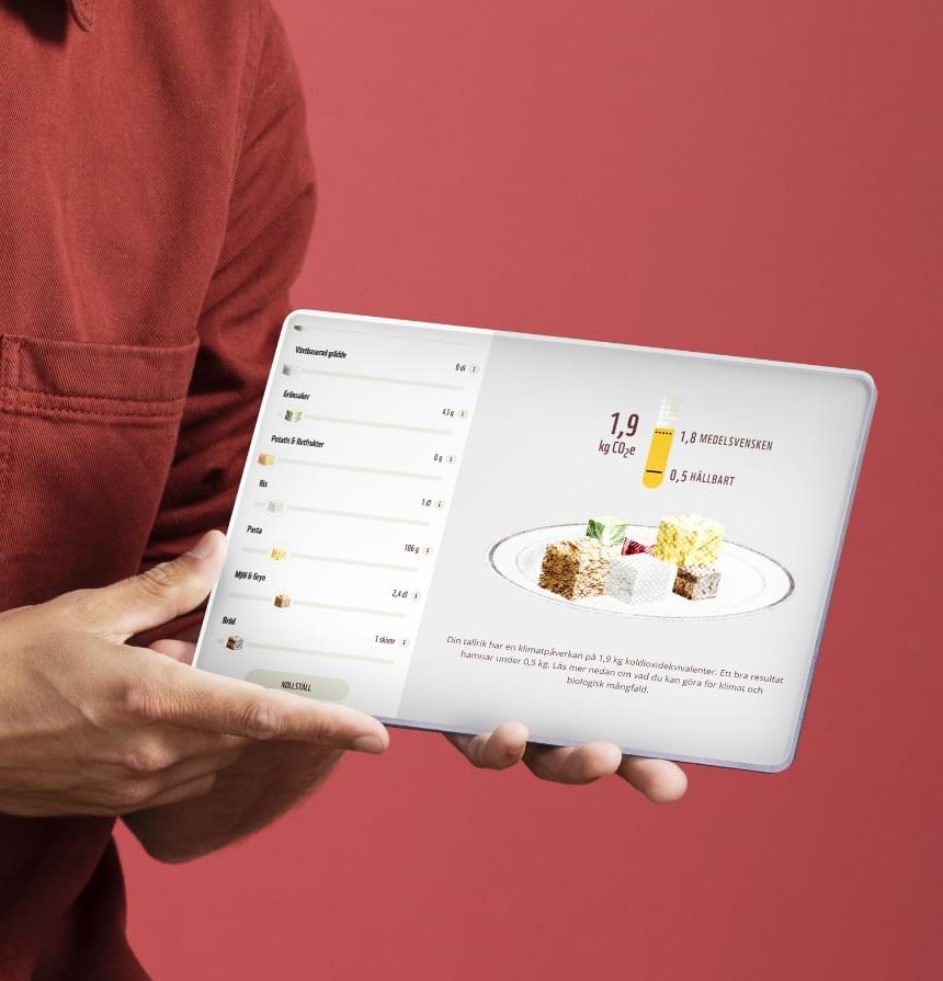 Person som håller i en iPad-liknande prototyp som visar webbapplikationen WWFs matkalkylator.